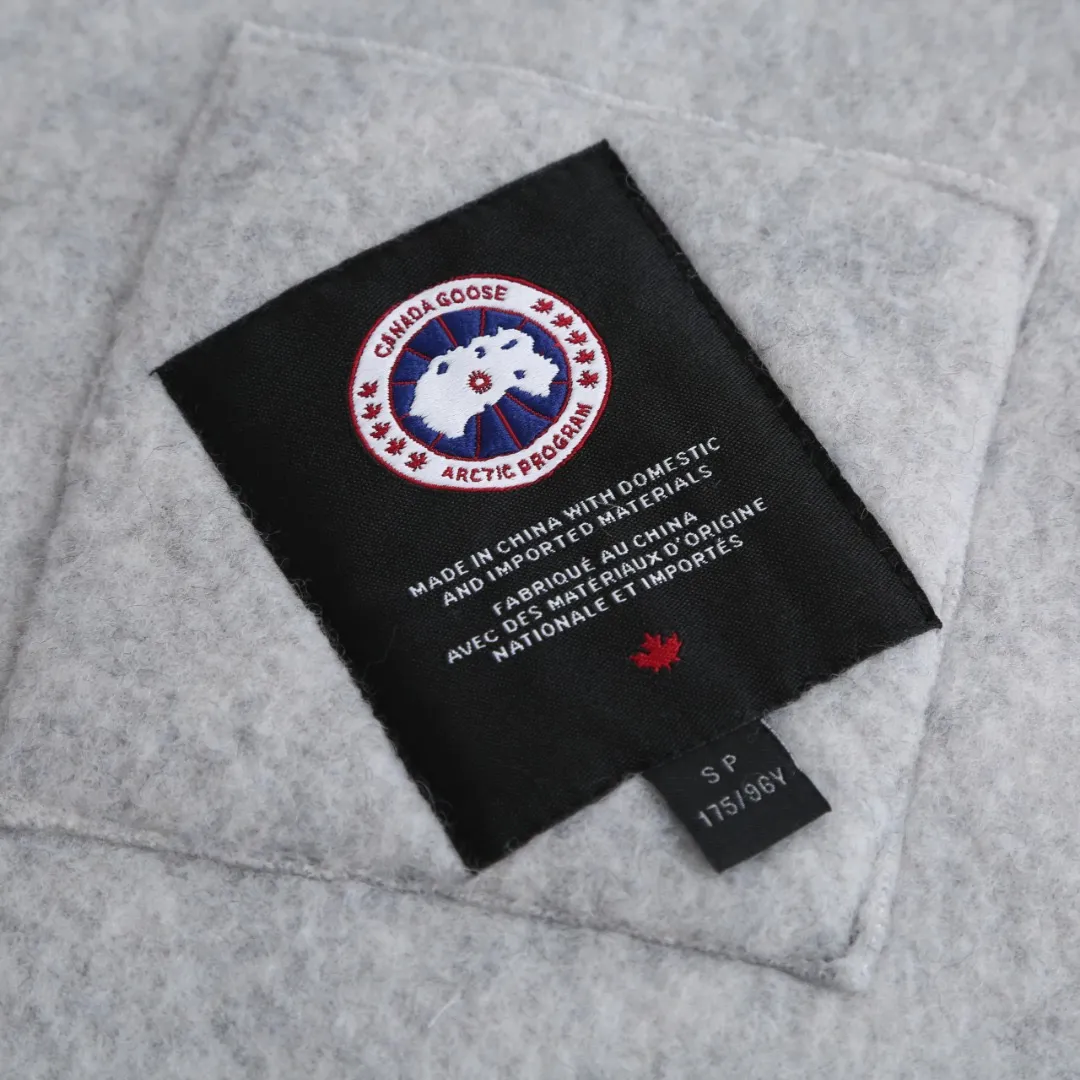 P780 Canada Goose Wool Fleece Hooded Jacket (Light Gray) The fabric is made of wool fleece fabric, which is mainly made of wool and mixed with a very small amount of spandex and polyester fiber. Wool is a core natural ingredient that provides unparalleled temperature regulation, antibacterial and anti-odor properties and a skin-friendly feel. The feeding of a small amount of spandex gives the fabric a certain degree of four-way elasticity, making it non-restrictive during daily activities. As the basis of fleece's structure, polyester fiber enhances the fabric's durability, wrinkle resistance and quick-drying properties. It contributes to the loft of the fleece and provides functions such as trapping air. The sleeves and hem are closed with 2×2 ribbing. Its strong elasticity can closely fit wrists and waists of different thicknesses, forming an effective 'seal' to prevent cold wind from blowing back. It can still maintain its original shape after repeated stretching and use, and is not easy to loose and deform. And the ribbed cuffs can convey a sense of design and enhance the visual beauty. The combination of hood design and elastic buckle improves warmth and windproof performance when worn. Size:S-M-L-XL